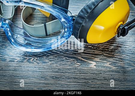 Lunettes de sécurité couvre-oreilles sur panneau en bois. Banque D'Images