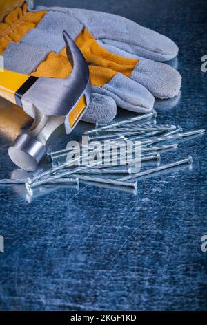 Ensemble de gants de sécurité pour clous métalliques et marteau à griffe sur surface métallique rayée concept de construction. Banque D'Images