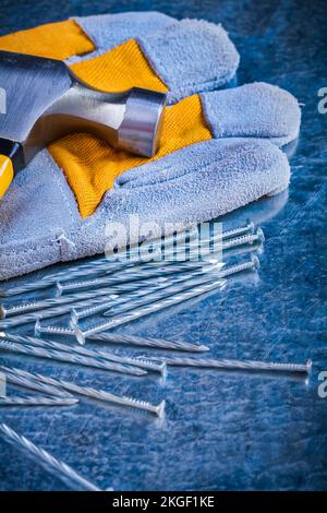 Fabrication de gants de sécurité clous et marteau à griffe sur fond métallique rayé concept d'entretien. Banque D'Images