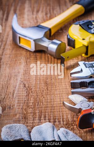 jeu d'outils à main marteau clé à ruban pince pince pince-nippers gant sur le concept de construction en bois d'époque Banque D'Images