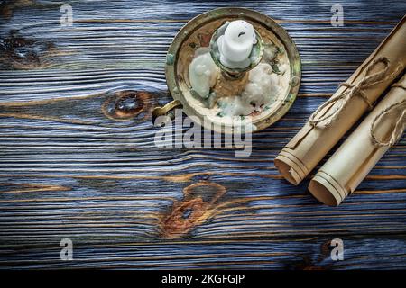 Rouleaux de papier d'époque bougie chandelier sur panneau bleu en bois. Banque D'Images