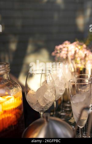 Verres de cocktails au bar. Verres de vin mousseux avec alcool rouge. Cocktail Preraring aperol spritz dans le bar extérieur d'été Banque D'Images