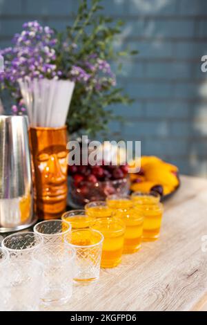 Verres de cocktails au bar. Verres de vin mousseux avec alcool rouge. Cocktail Preraring aperol spritz dans le bar extérieur d'été Banque D'Images