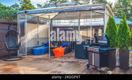 Terrasse extérieure en bois de maison privée avec auvent. Gril moderne Banque D'Images