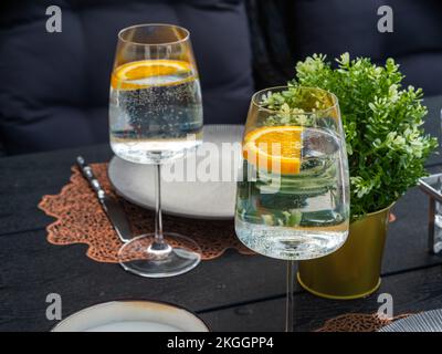 Gros plan avec deux verres d'eau et de citron. Table servie. Fleurs Banque D'Images