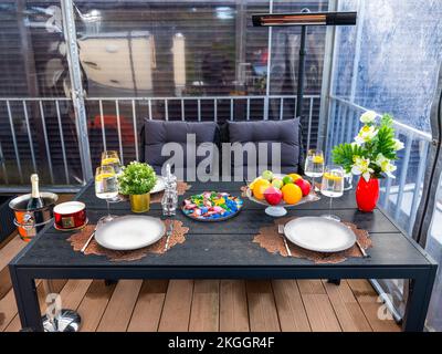 Table servie. Fruits, fleurs et boissons. Chaises confortables. Terrasse extérieure Banque D'Images