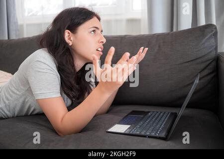 Jeune fille de chat avec des amis en ligne sur ordinateur portable Banque D'Images