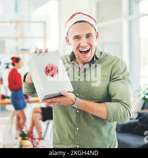 Noël, bureau de collègue et cadeau pour homme d'affaires heureux et excité pendant la fête de vacances avec le cadeau secret de Santa. Portrait d'un employé Banque D'Images