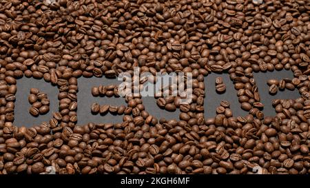 Inscription sur les grains de café sans caféine, vue de dessus du café, inscription avec café sur fond noir. Banque D'Images