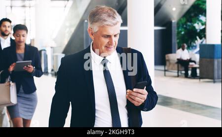 Téléphone, senior et homme d'affaires se déplaçant à la réunion, à la conférence ou à l'atelier, à l'envoi de SMS et dans un immeuble de bureaux. Vérification de l'entreprise, du patron et de l'équipe des employés Banque D'Images