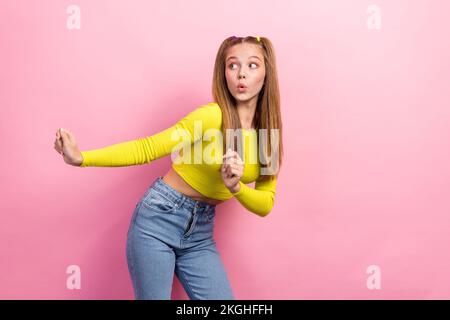 Photo d'une écolière adorable sans voix avec queues de cheval vêtue jaune manches longues look vide espace isolé sur fond jaune couleur Banque D'Images