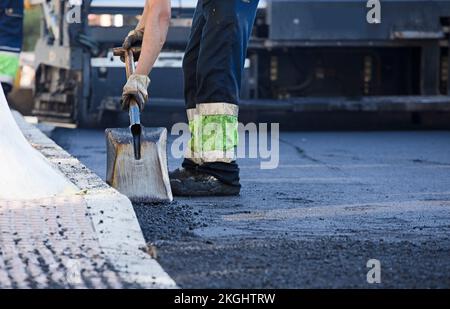 asphalte dans la ville opérateurs travaillant avec des outils et uniforme Banque D'Images