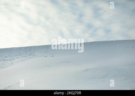 Pente enneigée contre le ciel.Avalanche de neige sur la crête de montagne.Temps d'hiver.Blanc désert dans le froid. Banque D'Images