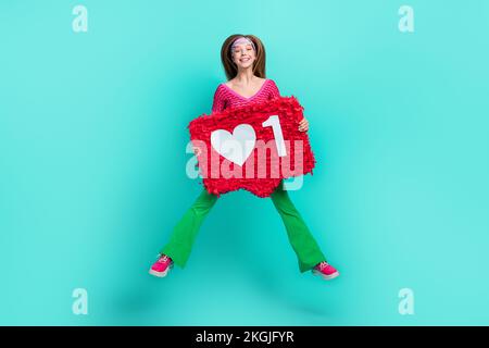 Pleine photo de gaie douce écolière porter rose pantacourt haut évasement pantalon coeur montant comme pinata isolé couleur turquoise fond Banque D'Images