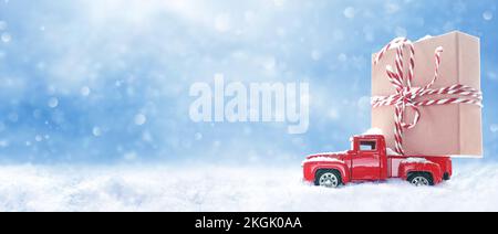 Fond de Noël avec neige et voiture rouge rétro avec boîte cadeau. .Carte d'hiver de voeux pour joyeux Noël et bonne année avec espace copie Banque D'Images