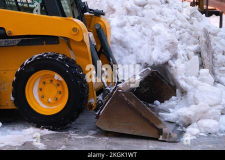 Un engin de terrassement de grande capacité nettoie la neige des trottoirs après un blizzard. Banque D'Images