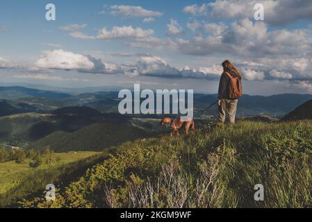 Fille de randonneur avec chien sur le sentier de randonnée en montagne Banque D'Images