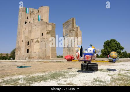 Shakhrisabz Ouzbékistan - ruines de l'immense arche d'entrée du palais Ak Serai (Palce blanc) construit par Amir Temur avec aire de jeux pour enfants Banque D'Images