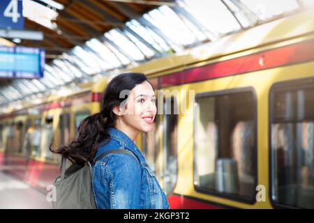 Allemagne, Berlin, jeune femme attendant devant le train de la ville Banque D'Images