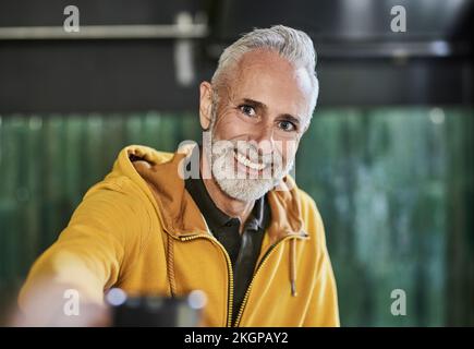 Joyeux homme mature portant une chemise à capuchon jaune Banque D'Images