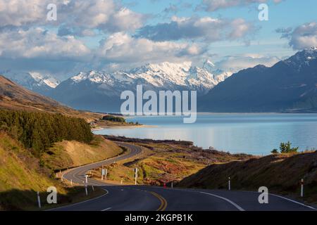 Nouvelle-Zélande, région de Canterbury, route asphaltée Winding avec le lac Pukaki et le mont Cook en arrière-plan Banque D'Images