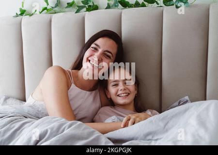 Bonne mère et bonne fille se détendant sur le lit Banque D'Images