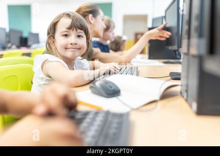 Un étudiant souriant en classe informatique à l'école Banque D'Images