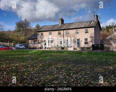 À l'extérieur du PuddleDucks Tea Room, couple mangeant de la crème glacée et appréciant le soleil de novembre à Dunsop Bridge, Lancaster Banque D'Images