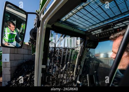 Homme mature exploitant une pelle hydraulique à l'usine de recyclage Banque D'Images