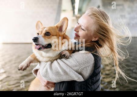 Femme souriante regardant la jolie Pembroke gallois Corgi Banque D'Images