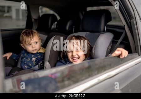 Heureux frères et sœurs assis à l'arrière de la voiture Banque D'Images