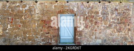 Panorama - ancien mur en pierre avec porte en bois bleu clair Banque D'Images