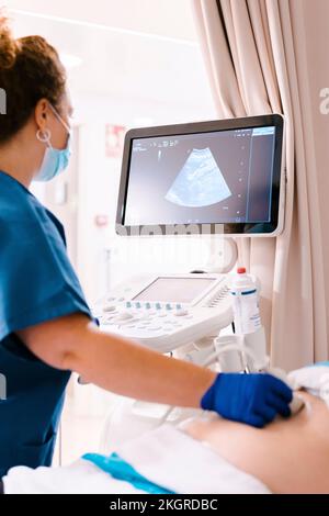 Infirmière mature qui examine le patient à l'aide d'un échographe Banque D'Images