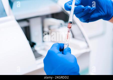 Mains du médecin analysant des échantillons de sang en laboratoire Banque D'Images