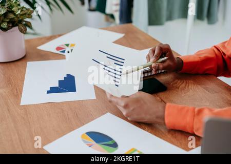 Mains d'une femme d'affaires examinant le graphique au bureau Banque D'Images