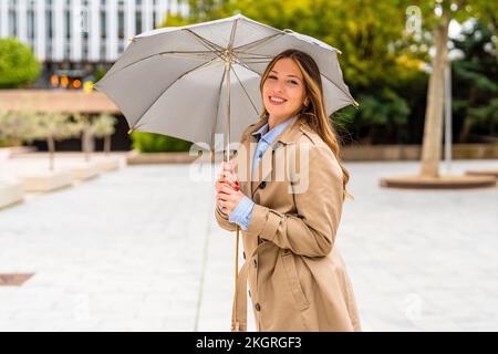 Bonne femme d'affaires tenant un parapluie sur la piste de marche Banque D'Images