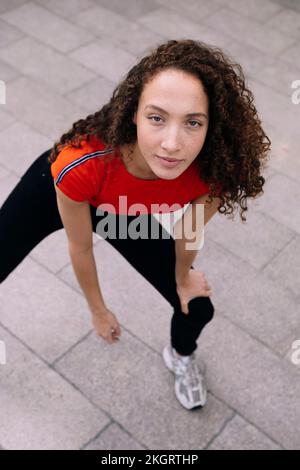 Jeune femme aux cheveux bouclés debout sur le sentier Banque D'Images