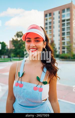 Jeune femme souriante portant un pare-soleil sur le terrain de sport Banque D'Images