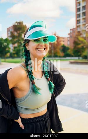 Jeune femme heureuse portant un pare-soleil sur le terrain de sport Banque D'Images