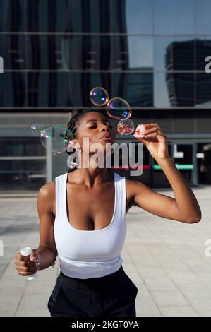 Bonne femme soufflant des bulles en appréciant sur le sentier Banque D'Images