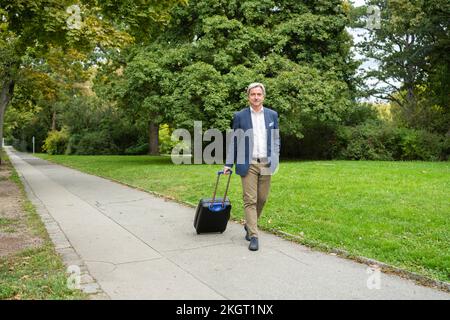 Homme d'affaires avec bagages marchant sur la piste Banque D'Images