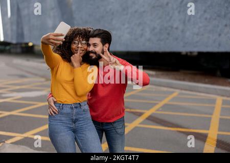 Un jeune couple heureux prend le selfie par le biais d'un smartphone sur la piste de marche Banque D'Images