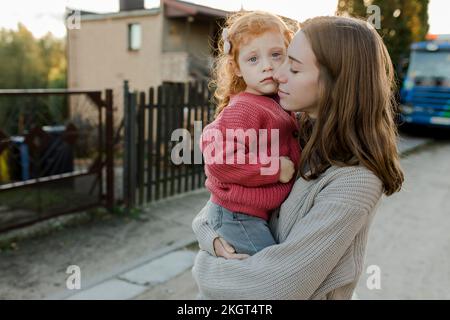 Femme avec les yeux fermés portant la fille Banque D'Images