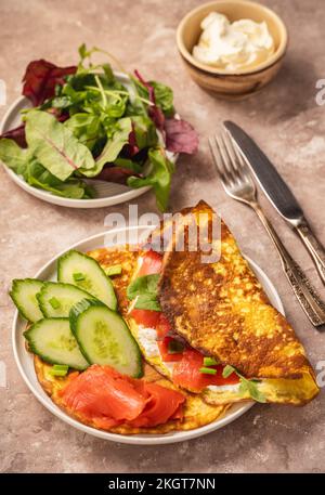 Déjeuner au keto - crêpes au keto servies avec de la ricotta et du saumon fumé sur fond rustique. Banque D'Images