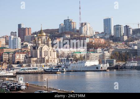 Vladivostok, Russie - 11.03.2022: Paysage urbain de Vladivostok le jour ensoleillé de la mer avec église dorée sur la côte Banque D'Images