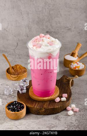 Boba ou perles de tapioca est le thé de lait à bulles de taïwan dans une tasse en plastique avec saveur de guimauve sur fond de texture, rafraîchissement d'été. Banque D'Images
