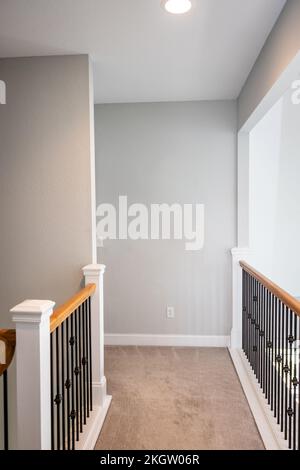 Un long couloir au niveau supérieur balcon avec des murs gris clair modernes Banque D'Images