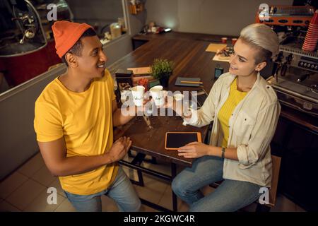 Des employés de cafés gais boivent des boissons caféinées sur le lieu de travail Banque D'Images
