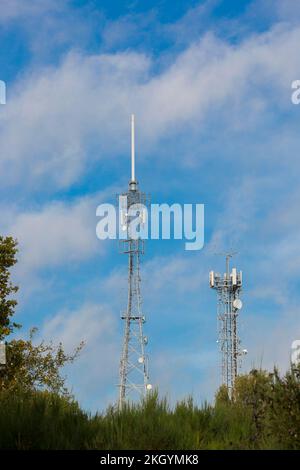 De grands mâts de téléphone mobile britanniques à l'extérieur sous le soleil avec fond bleu ciel. Banque D'Images