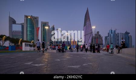 Photo de la corniche de Doha au coucher du soleil montrant la préparation du Qatar pour la coupe du monde de la FIFA Qatar 2022 avec les habitants et les visiteurs marchant sur la promenade Banque D'Images